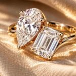 A bespoke Toi et Moi ring pairing a pear-cut and emerald-cut diamond on a curved gold band.